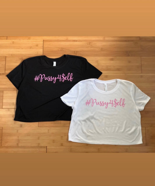 #pussy4self crop top tees black & white with pink imprint on a wooden background.